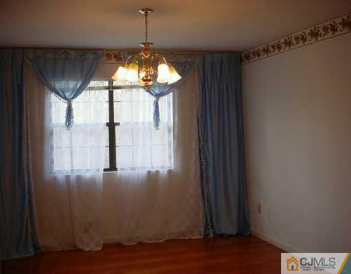 3 Churchill Road Edison, NJ 08820 - Photo 3 of 8 a view of a room with wooden floor and chandelier