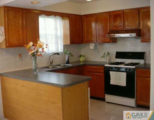 3 Churchill Road Edison, NJ 08820 - Photo 4 of 8 a kitchen with stainless steel appliances granite countertop a sink a stove and a microwave
