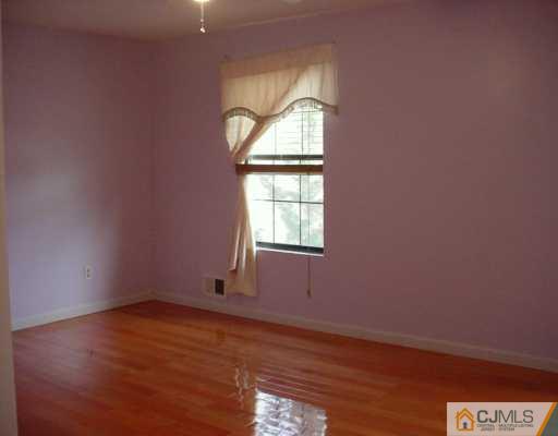 3 Churchill Road Edison, NJ 08820 - Photo 6 of 8 an empty room with wooden floor and windows