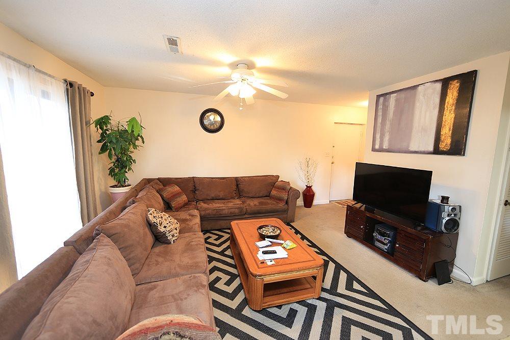 524 Pine Ridge Place, Unit 524 Raleigh, NC 27609 - Photo 4 of 12 a living room with furniture and a flat screen tv