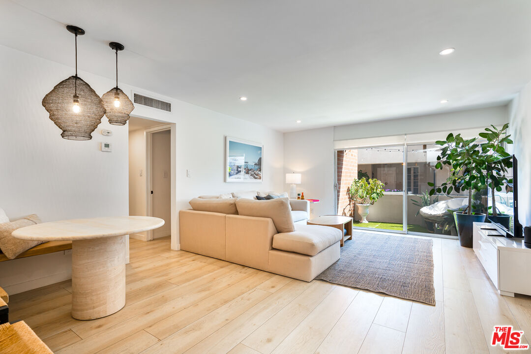 11750 Sunset Boulevard, Unit 407 Los Angeles, CA 90049 - Photo 2 of 12 a living room with furniture and a wooden floor