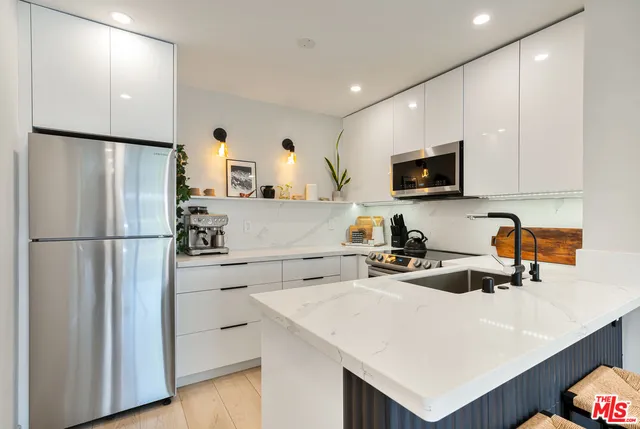 a kitchen with a refrigerator a stove a sink a microwave and cabinets