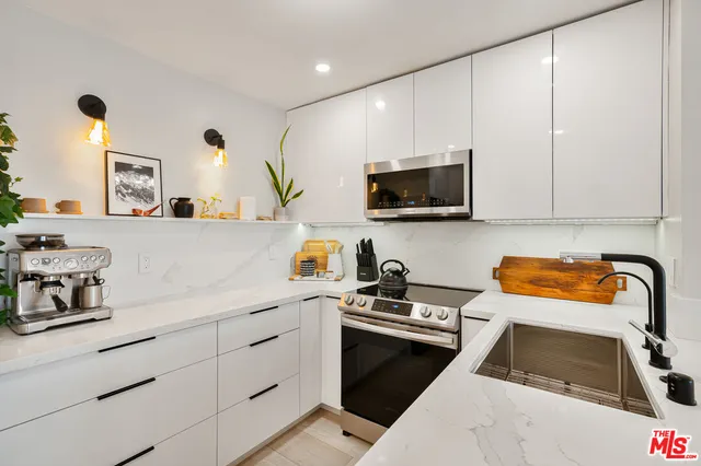 a kitchen with a sink a stove and cabinets
