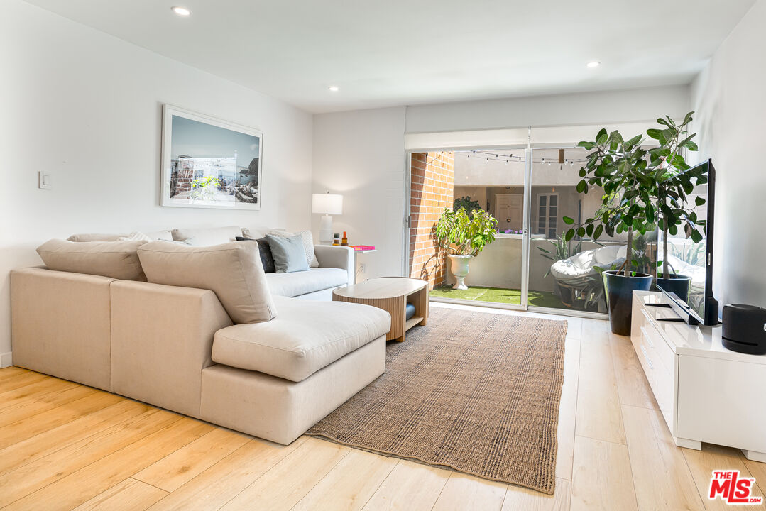 11750 Sunset Boulevard, Unit 407 Los Angeles, CA 90049 - Photo 7 of 12 a living room with furniture and a potted plant