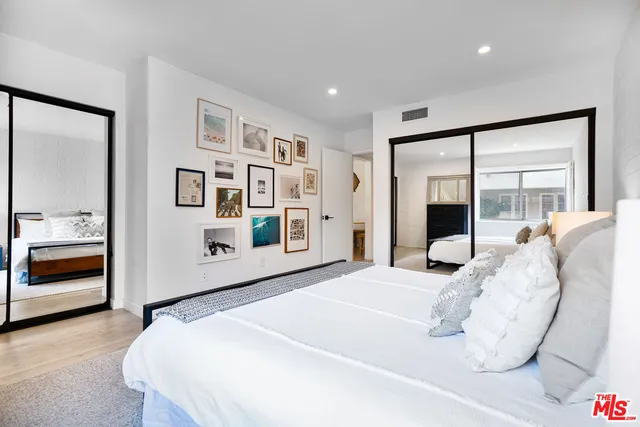 a bedroom with a large bed and a large mirror