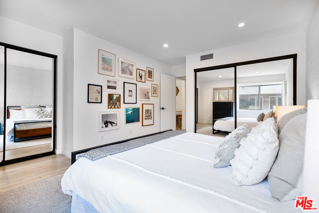 11750 Sunset Boulevard, Unit 407 Los Angeles, CA 90049 - Photo 9 of 12 a bedroom with a large bed and a large mirror