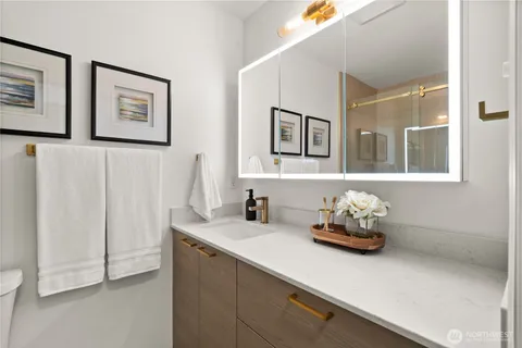 a bathroom with a sink mirror and painting on the wall