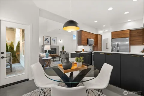 a dining room with furniture a rug a potted plant and a chandelier