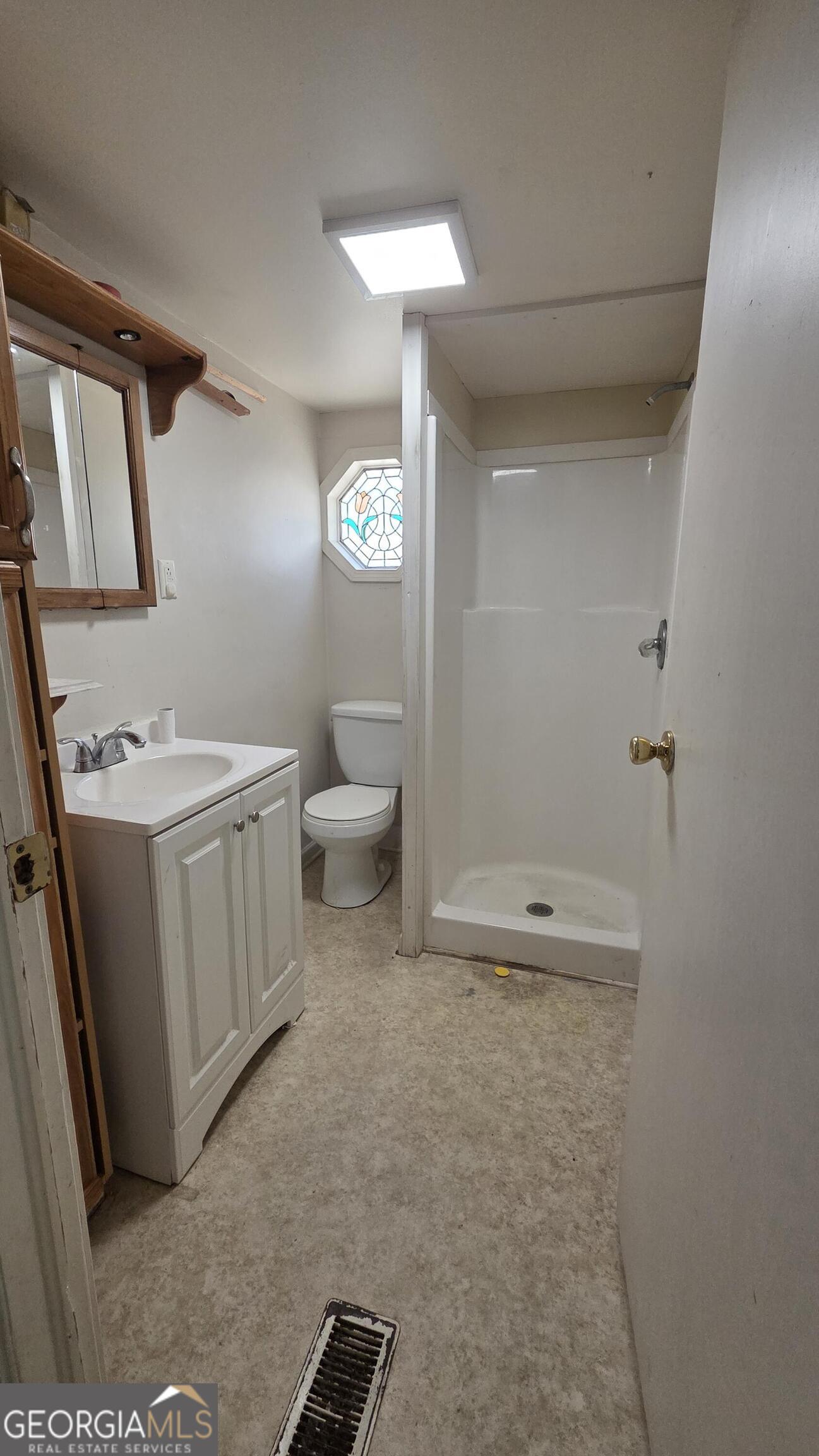 25 Fischer Road Sharpsburg, GA 30277 - Photo 14 of 22 a bathroom with a sink a toilet a light fixture and a mirror