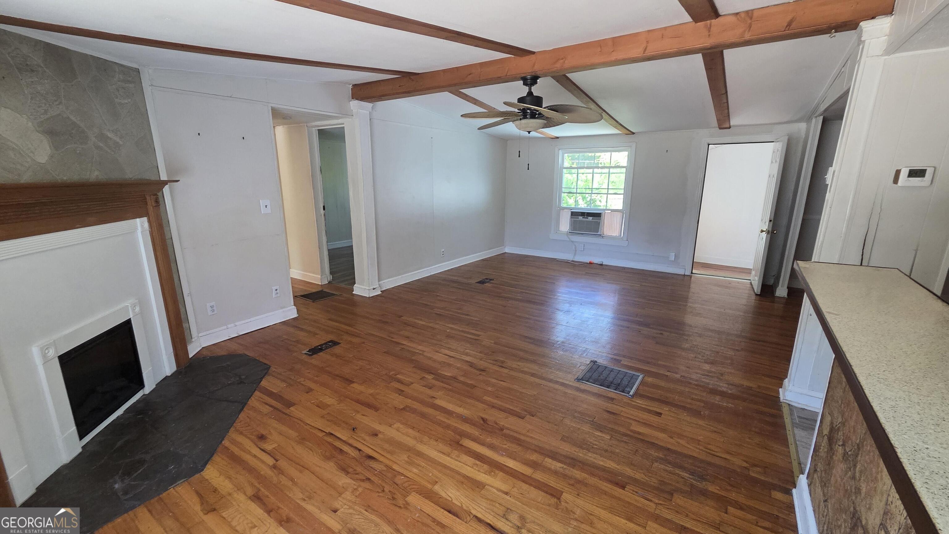 25 Fischer Road Sharpsburg, GA 30277 - Photo 6 of 22 a view of empty room with wooden floor and fireplace