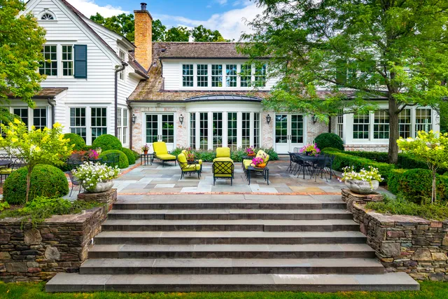 a kitchen with stainless steel appliances granite countertop a table chairs stove and white cabinets