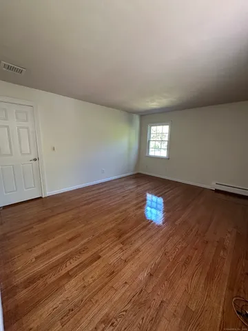 a view of a room with wooden floor