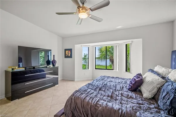 a bedroom with a bed and a large window with the outer view