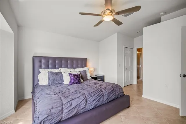 a bedroom with a large bed and a ceiling fan