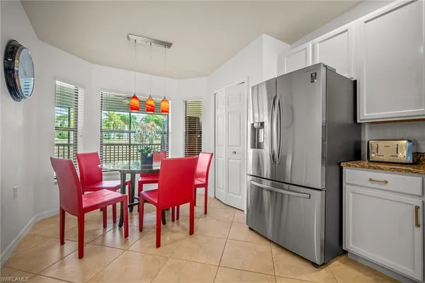 a kitchen with stainless steel appliances a refrigerator a table and chairs