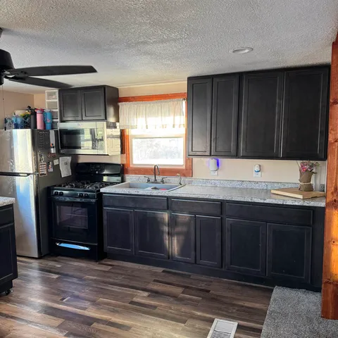 a kitchen with stainless steel appliances granite countertop a stove a sink dishwasher and a refrigerator