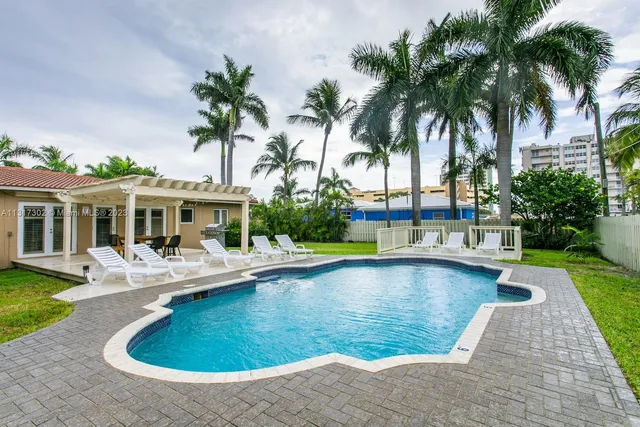 a view of a house with swimming pool and sitting area