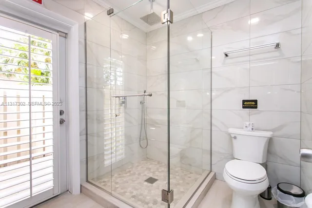a bathroom with a shower toilet and a window
