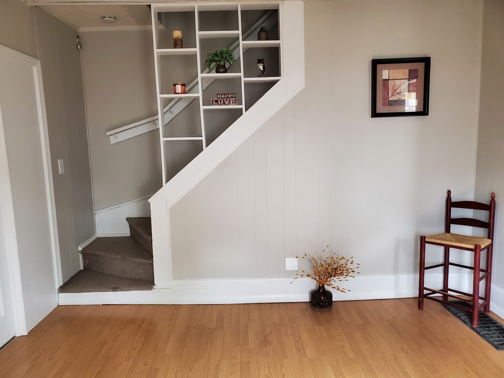 80-84 Keith Street Springfield, MA 01108 - Photo 2 of 4 a view of an empty room with wooden floor and stairs
