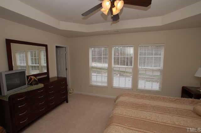 7038 Racine Way Raleigh, NC 27615 - Photo 9 of 12 a bedroom with a bed and wooden floor
