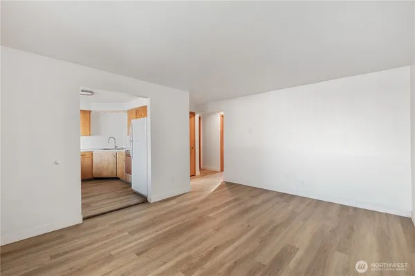 an empty room with wooden floor and bathroom view