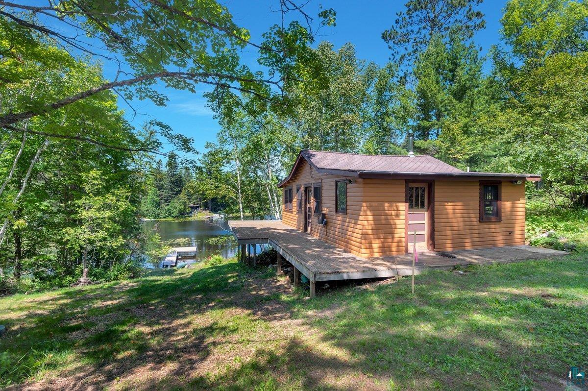 Back of house featuring a yard and a water view