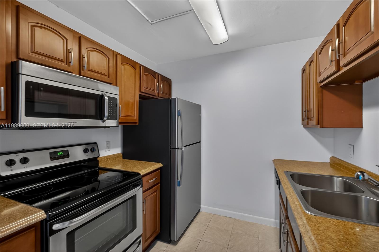 400 Southwest 134th Way, Unit 112F Pembroke Pines, FL 33027 - Photo 9 of 40 a kitchen with stainless steel appliances granite countertop a stove microwave and refrigerator