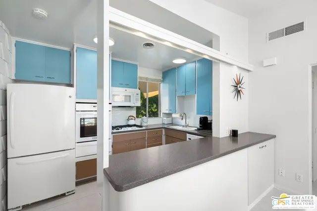 a kitchen with stainless steel appliances granite countertop a sink and a refrigerator