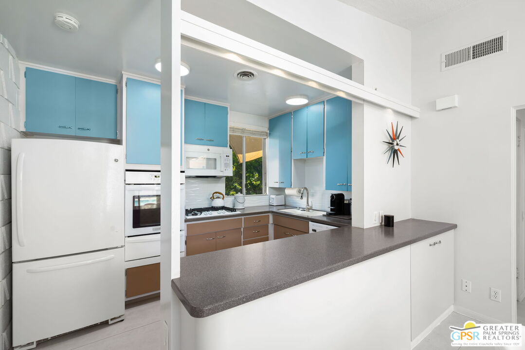 1655 Andee Drive Palm Springs, CA 92264 - Photo 13 of 26 a kitchen with stainless steel appliances granite countertop a sink and a refrigerator