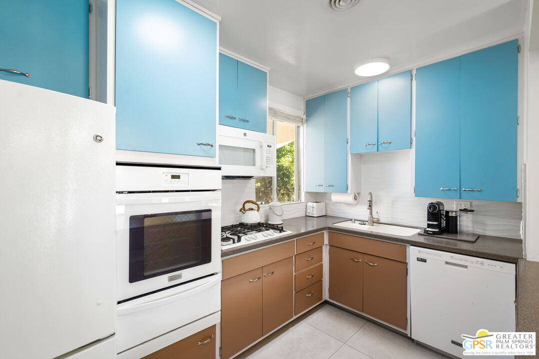 1655 Andee Drive Palm Springs, CA 92264 - Photo 14 of 26 a kitchen with a sink stove top oven and cabinets