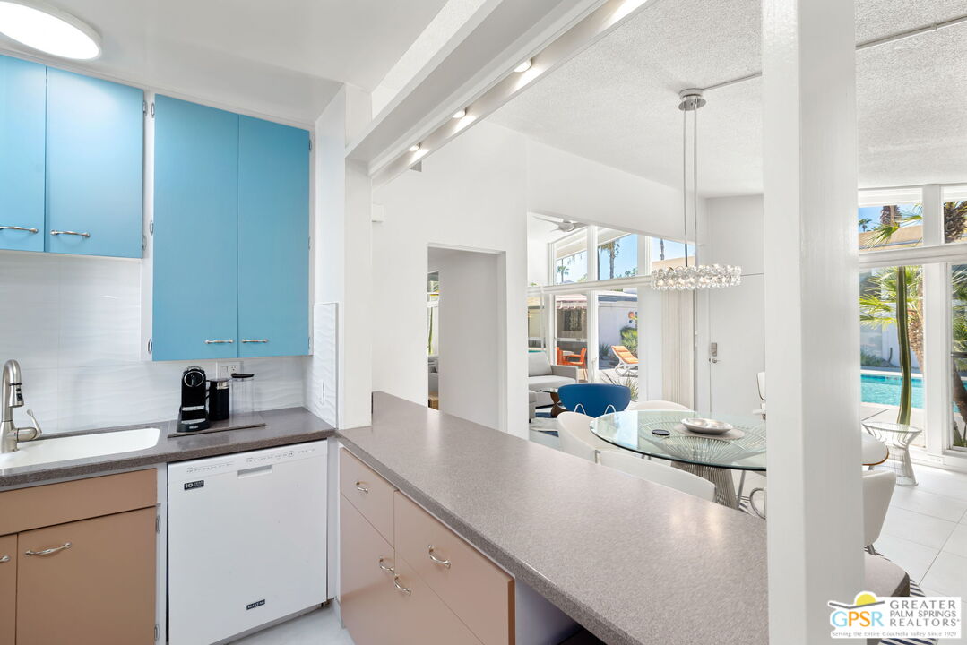 1655 Andee Drive Palm Springs, CA 92264 - Photo 15 of 26 a kitchen with a sink dishwasher and white cabinets next to a window