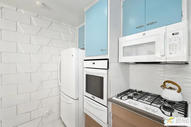 a kitchen with granite countertop white cabinets and white appliances