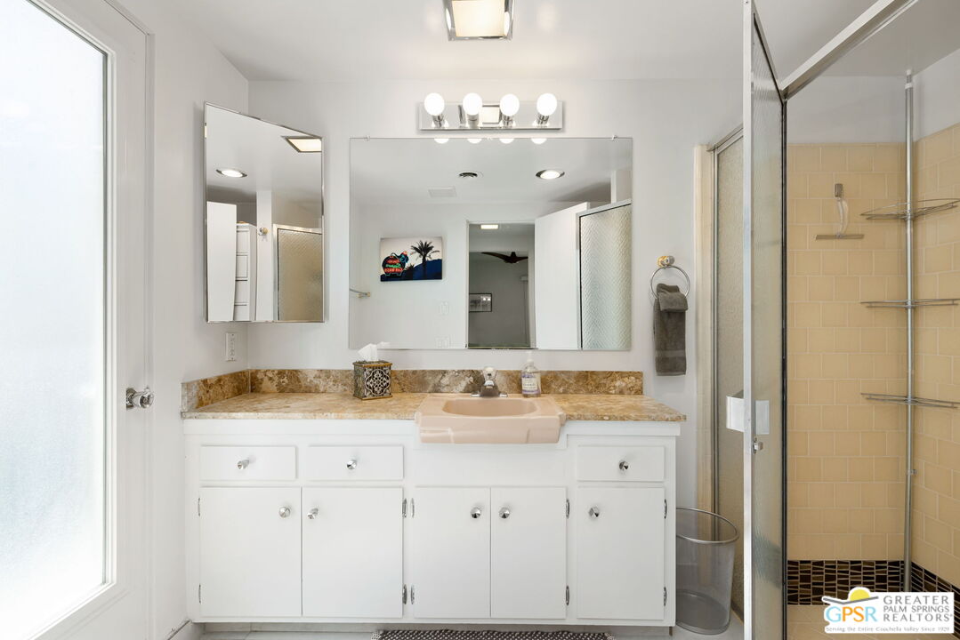 1655 Andee Drive Palm Springs, CA 92264 - Photo 20 of 26 a bathroom with a granite countertop sink a mirror and a shower