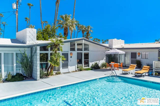 a view of a house with a big yard and potted plants