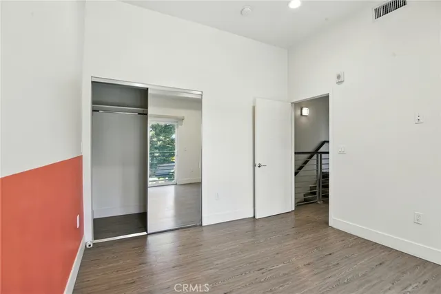 an empty room with wooden floor and closet