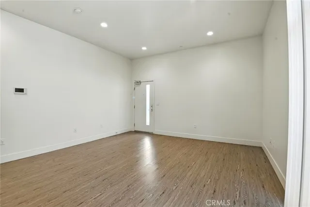 a view of room with wooden floor and white walls