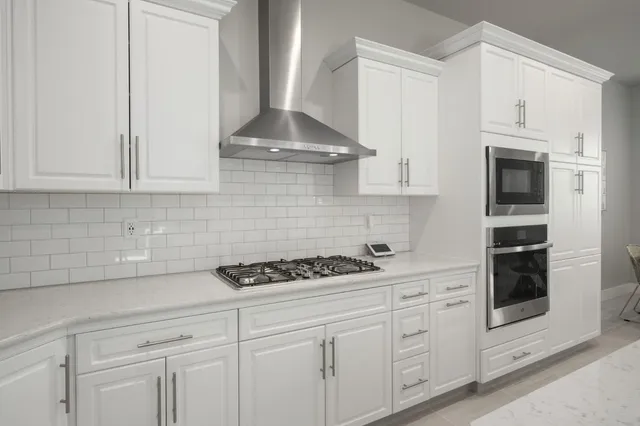 a kitchen with white cabinets and appliances