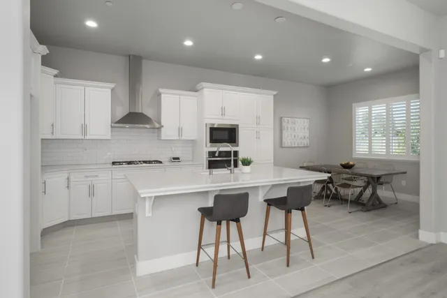 a kitchen with stainless steel appliances granite countertop a stove a sink a refrigerator and a microwave