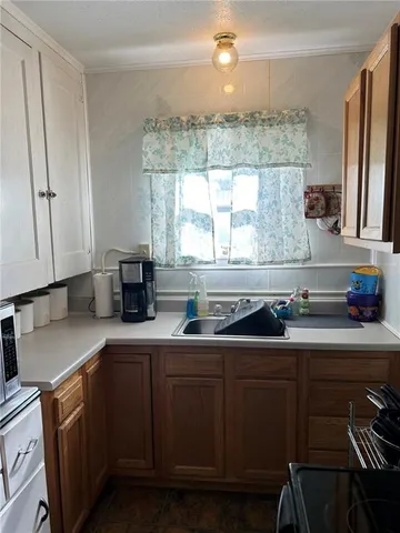 a kitchen with a sink a window and cabinets
