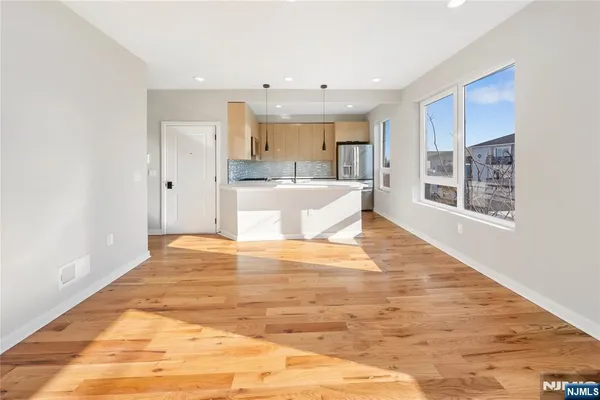 a view of a kitchen with kitchen island wooden floor and living room