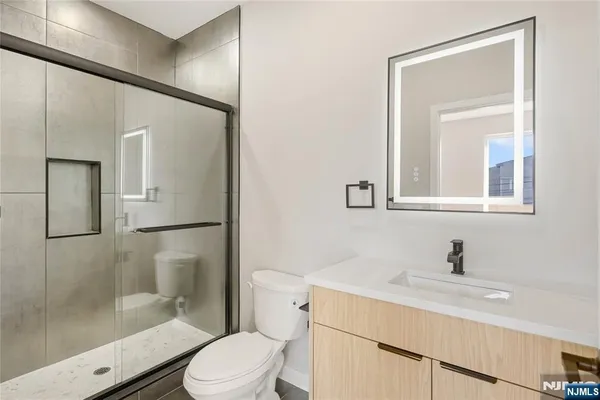 a bathroom with a sink toilet a mirror and shower