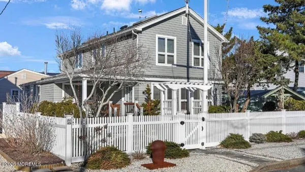 a view of a house with a small yard and wooden fence
