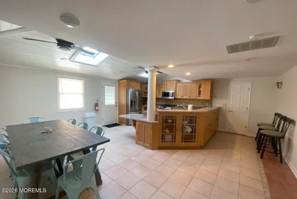 a kitchen with stainless steel appliances kitchen island granite countertop a refrigerator and a stove