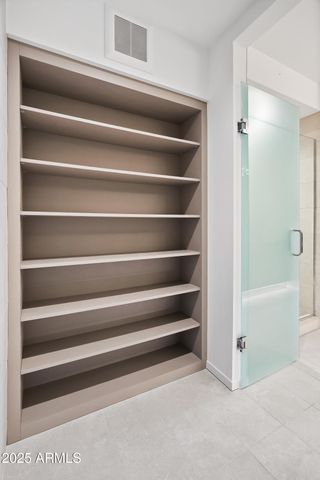 a view of walk in closet with clothes and shoes