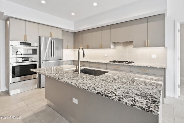 a kitchen with stainless steel appliances granite countertop a sink stove and refrigerator