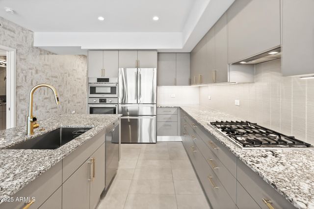 a kitchen with granite countertop a stove and a refrigerator