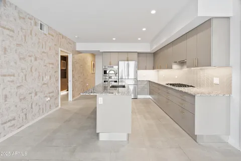 a kitchen with stainless steel appliances granite countertop a stove and a refrigerator