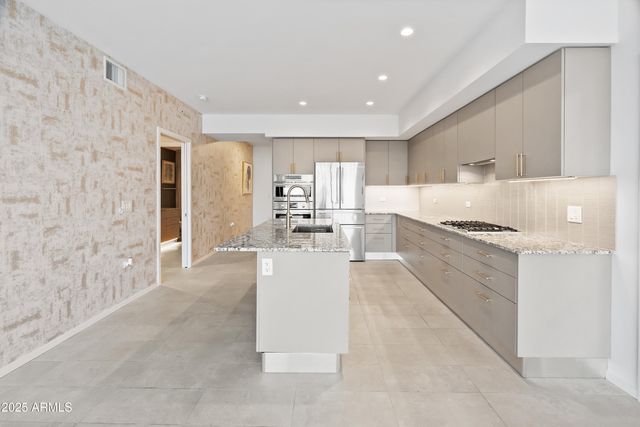 a kitchen with stainless steel appliances granite countertop a stove and a refrigerator