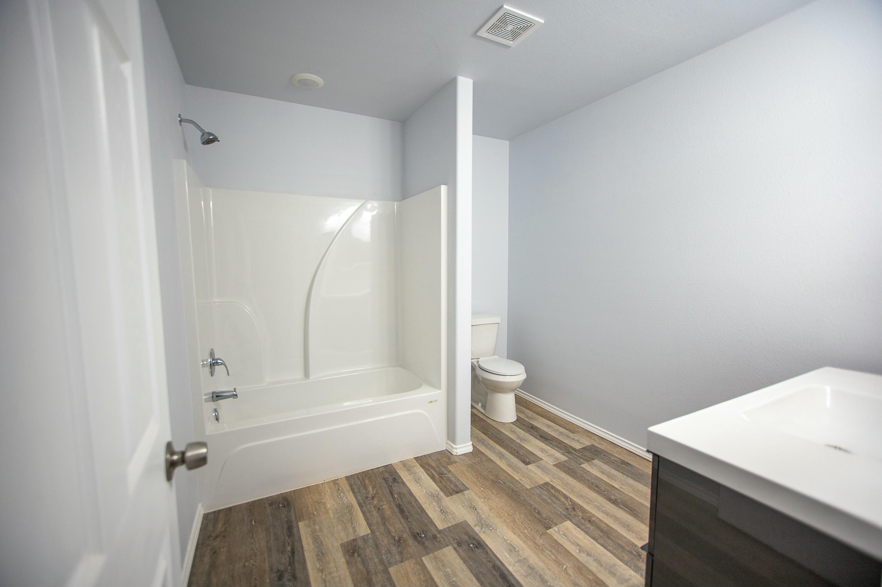 8613 10th Place Lubbock, TX 79416 - Photo 3 of 9 a bathroom with a sink a toilet and shower