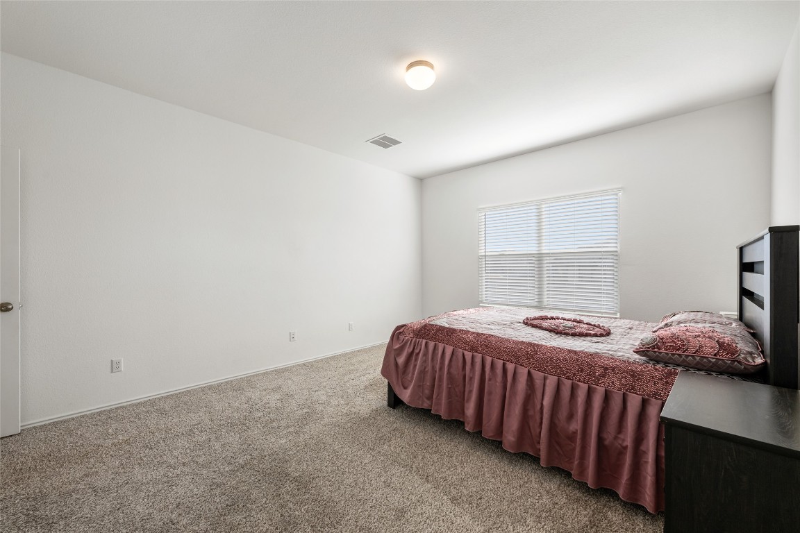 132 Joe Kidd Lane, Unit 132 Jarrell, TX 76537 - Photo 18 of 40 a bedroom with a bed and a window